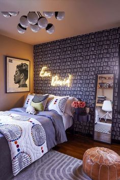 a bed room with a neatly made bed and a large mirror on the wall above it