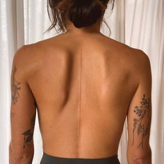 the back of a woman's body with tattoos