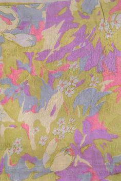 a yellow and purple floral print fabric with pink, blue, green, and white flowers