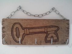 a wooden sign with a corkscrew and key on it hanging from a chain