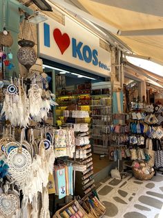 the inside of a store with lots of items on display and in front of it is a sign that says i love kos