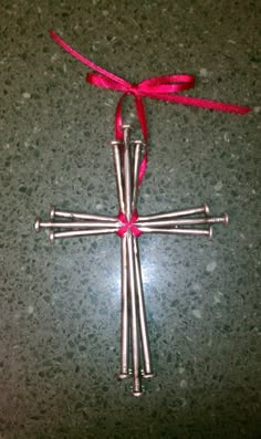 a cross ornament with red ribbon tied around it