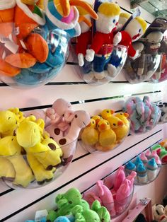 there are many stuffed animals hanging on the wall in this store that is filled with toys