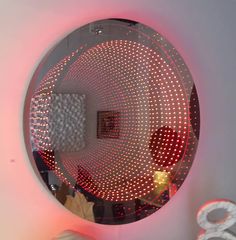 a round mirror with red lights on it