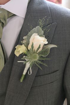 a man wearing a suit and tie with a boutonniere on his lapel