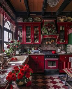 a kitchen with red cabinets and checkered flooring