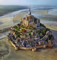 an aerial view of a castle in the middle of some water and land with sand around it