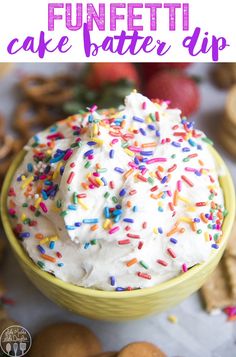 a bowl filled with white frosting and sprinkles next to crackers