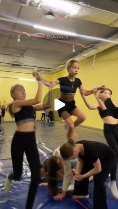 a group of people standing on top of a trampoline in a gym floor