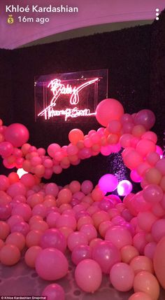 pink and white balloons are floating in the air at a birthday party with neon lights