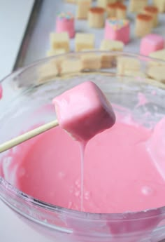 a bowl filled with marshmallows on top of a wooden stick in it