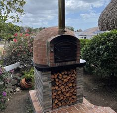 an outdoor brick oven with logs stacked in it