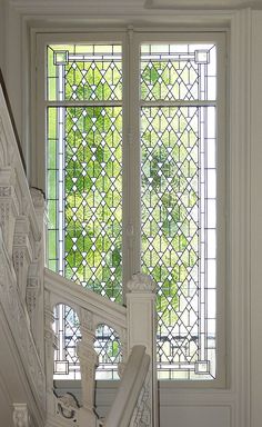 the stairs lead up to an ornate glass window