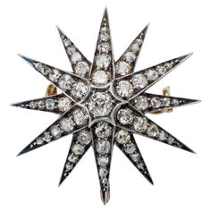 Dating from circa 1885-1890, this late Victorian star brooch is set with old mine-cut and rose-cut diamonds. It is designed as star with twelve arms set throughout with cushion and elongated cushion shape old mine, rose and single-cut diamonds, mounted in patinated silver-topped gold. Modern in its clean, geometric form, this versatile jewel, a product of highly skilled workmanship, showcases fiery old diamonds whose brilliance pops against the dark silver. Product Details: Item #: BO-21283 Coun Diamond Flower Brooch, Star Brooch, Emerald Eyes, Elongated Cushion, Demantoid Garnet, Gold Sign, Geometric Form, Silver Tops, Diamond Star