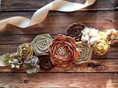 the flowers are made out of fabric and ribbon on top of wood planked boards