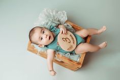 a baby laying on top of a wooden crate