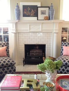 a living room filled with furniture and a fire place in front of a white fireplace