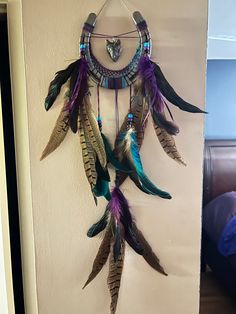 a dream catcher hanging on the wall next to a bed