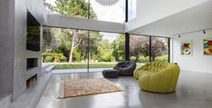 a living room filled with furniture and large windows