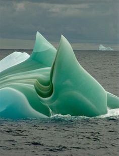 an iceberg floating in the middle of the ocean