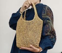 a woman holding a straw bag in her hands