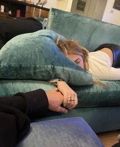 a woman laying on top of a blue couch