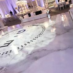 the floor is covered in white marble with black numbers on it and chandeliers hanging from the ceiling