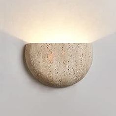 a light that is on the wall next to a lamp shade with a rock in it