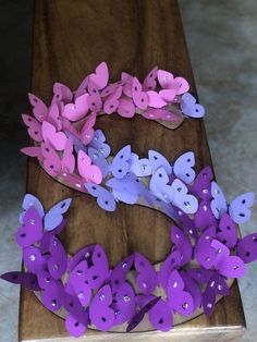 purple and pink paper butterflies on a wooden board