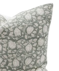 a gray and white pillow with flowers on it