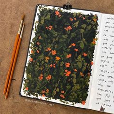 an open notebook with flowers on it and two pencils next to the book page