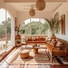 a living room filled with lots of furniture and plants on top of it's windows