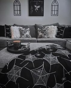 a black and white living room with spider webs on the couch, coffee table