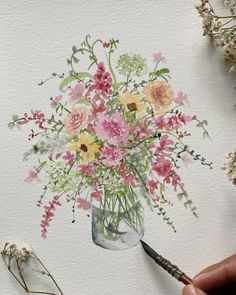 someone is painting flowers in a vase with watercolor pencils and paintbrushes