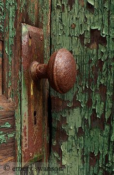 an old rusted door handle with green paint