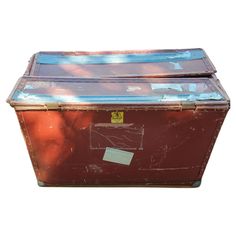 an old trunk is sitting in front of a white background and has a tag on it