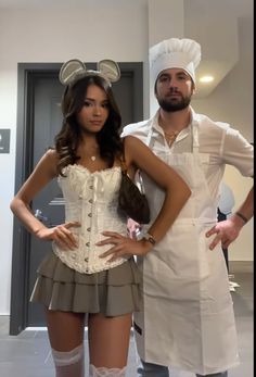 a man standing next to a woman wearing mickey mouse ears on her head and dress