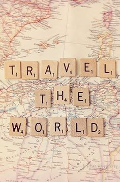 scrabble letters spelling travel the world on a map