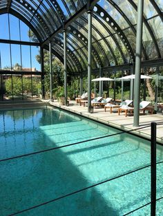 an indoor swimming pool surrounded by glass walls