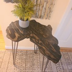 two wooden tables with metal legs and a potted plant on top