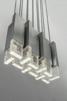 a modern chandelier hanging from the ceiling with square and rectangle shapes on it