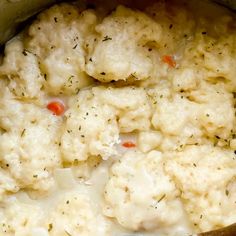 cauliflower and carrots cooking in a pot with a wooden spoon