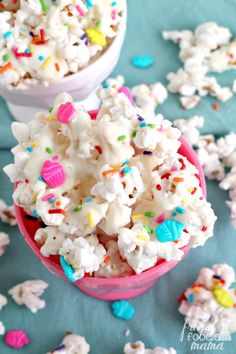 two bowls filled with white popcorn and sprinkles on a blue tablecloth