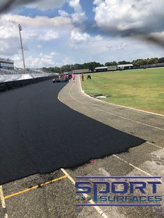 an asphalt track with people walking on it