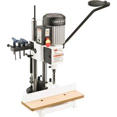 a machine that is sitting on top of a wooden board with tools attached to it