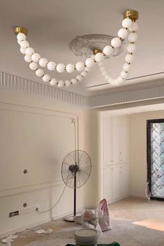 an empty room with some lights on the ceiling and a fan in the middle of the room