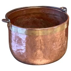 an old copper pot with handles on a white background