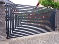 an iron gate is shown in front of a brick wall and sidewalk with trees on the other side