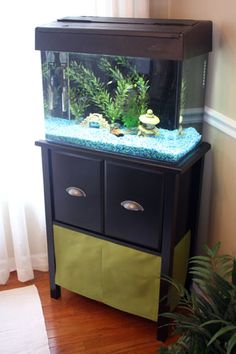 a fish tank sitting on top of a black cabinet