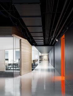 an empty office with glass walls and orange accents